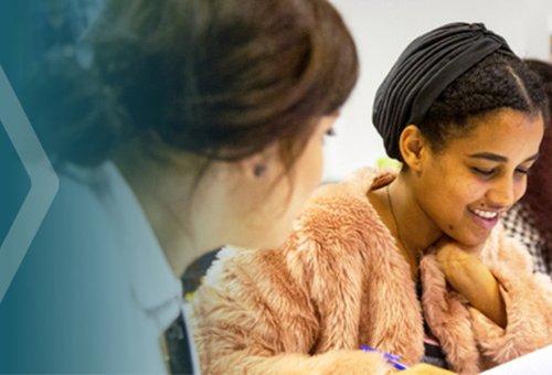 Two female students sat together in a classroom