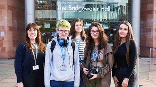 Five students stand outside the Bridgewater Hall in Manchester.