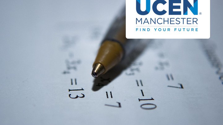 A pen lying across a piece of paper with equations written on