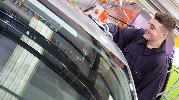 A Manchester College student repairing a car