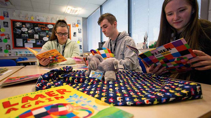 Childcare students looking at learning resources