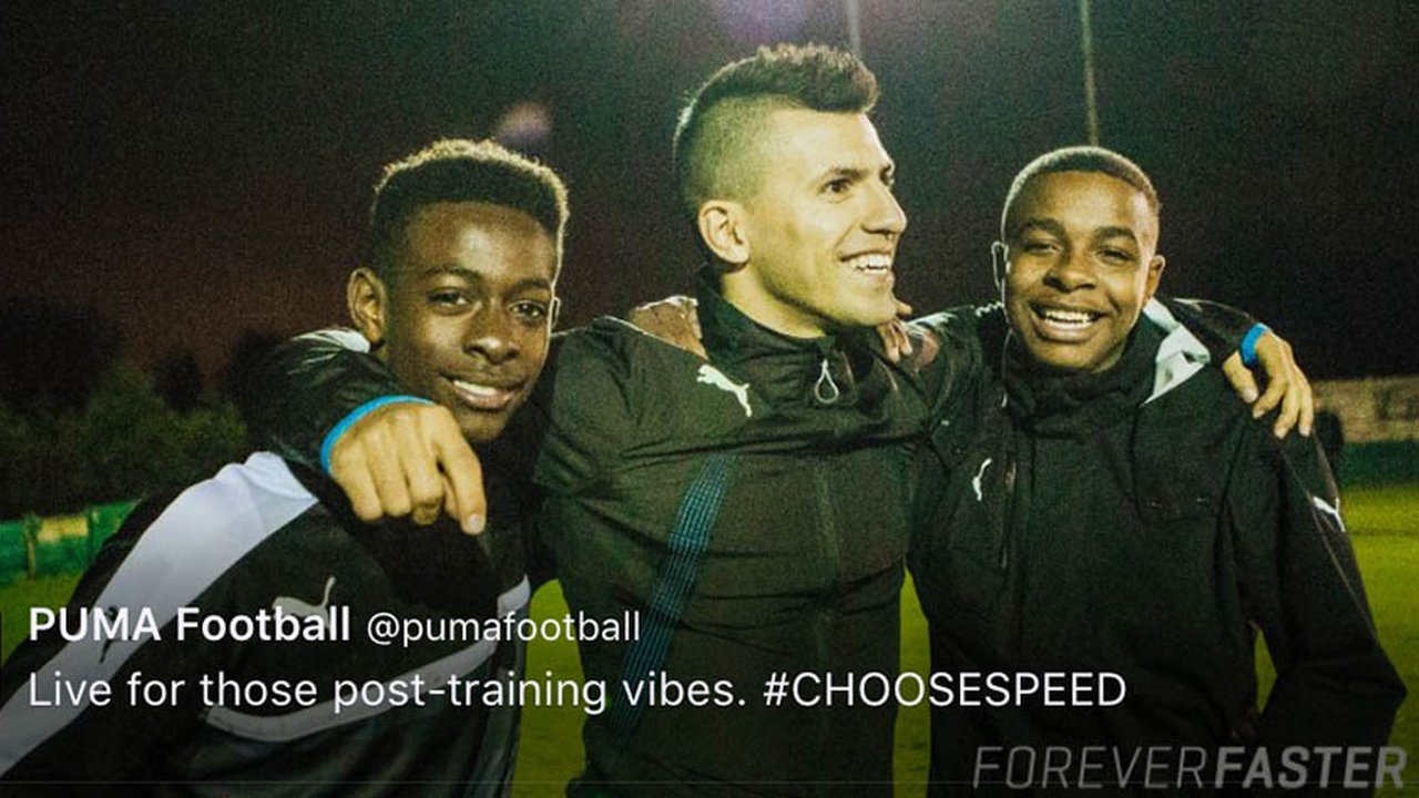 Two students smiling with Aguero from Manchester City