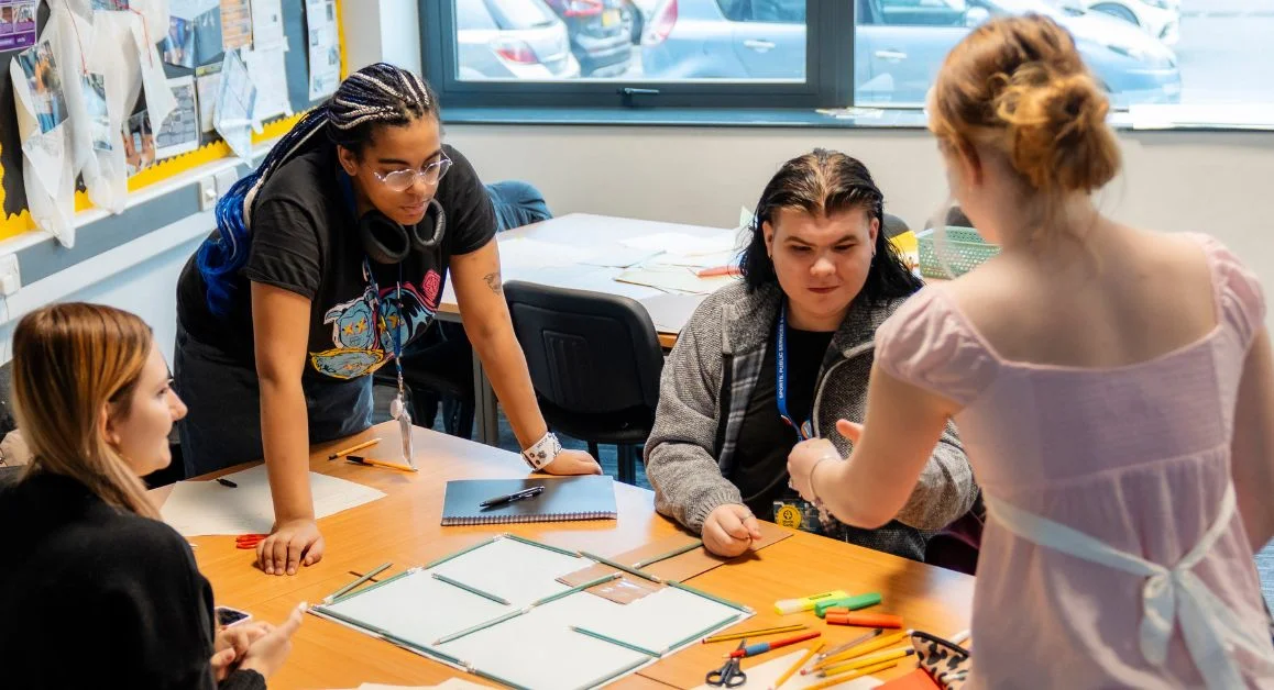 Four T Level students in a classroom working on a group project