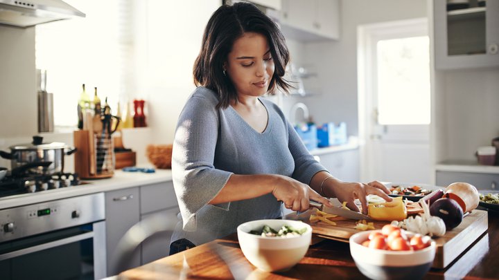 Shot of an young woman cooking a nutritious meal at home