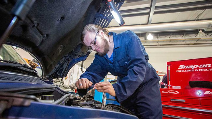 Mechanic looking under the bonnet of a car