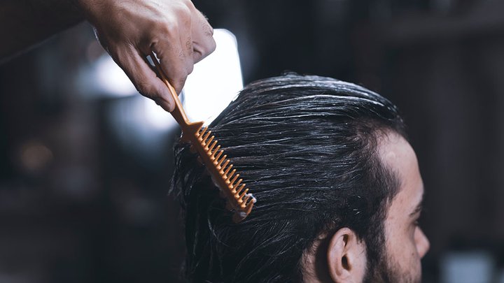 A mans hair being combed