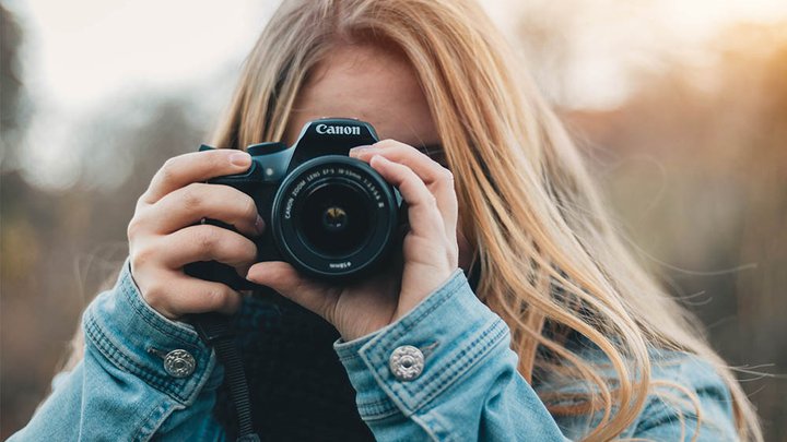 A student holding a canon DSLR