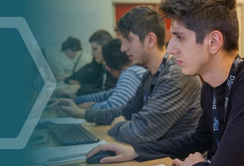 A row of students at computers in a classroom