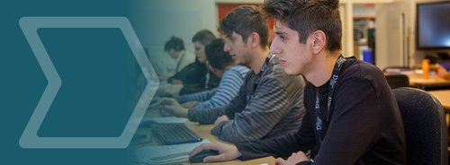 A row of students at computers in a classroom