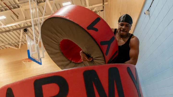 Close-up of a learner moving heavy objects during an exercise drill