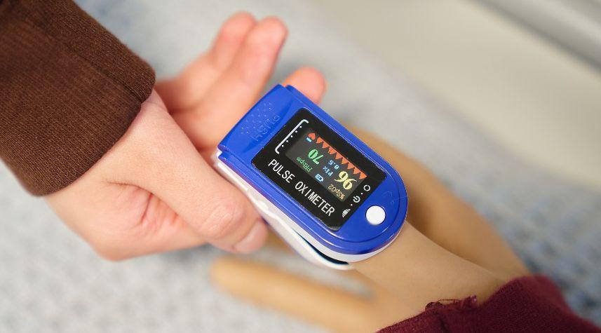 Close-up of a pulse oximeter placed on a person’s finger during a practical health care learning activity at The Manchester College.