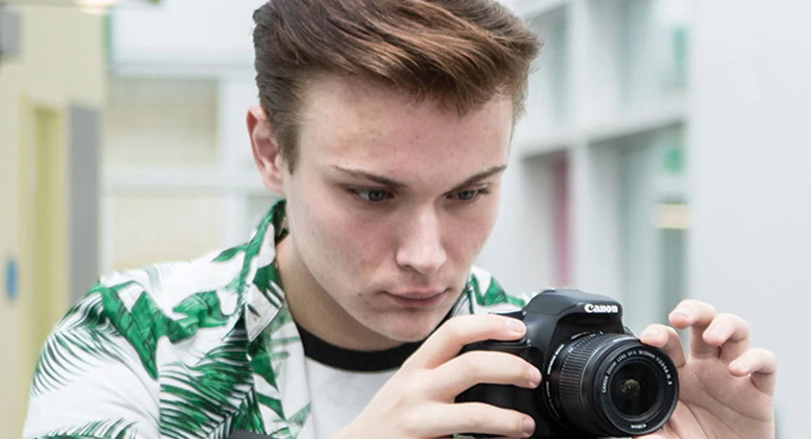 Person adjusting settings on a digital camera.