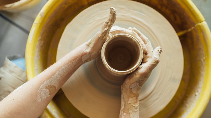 Hands of a potter. Potter making ceramic pot on the pottery wheel