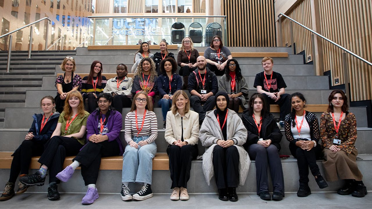 A group of Visual Arts students sit on the steps at City Campus Manchester with Suzanne Benson of Trowers and Hamlin sat in the middle of the bottom row.