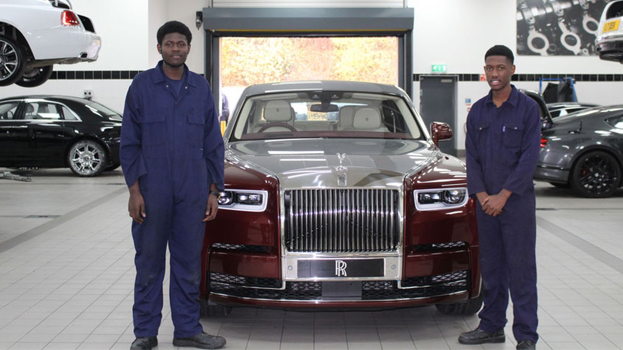 Two automotive students stood next to a Rolls Royce