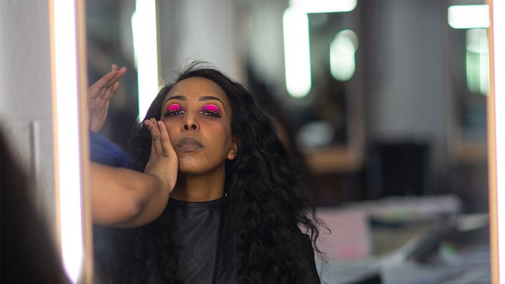 A student having theatrical make-up applied