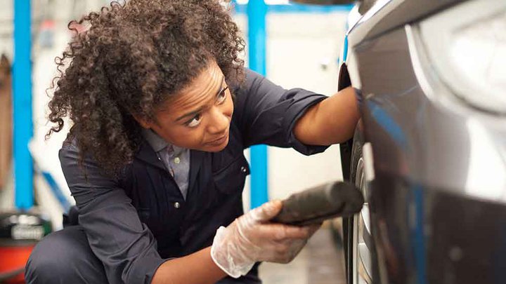 Female mechanic working on a car