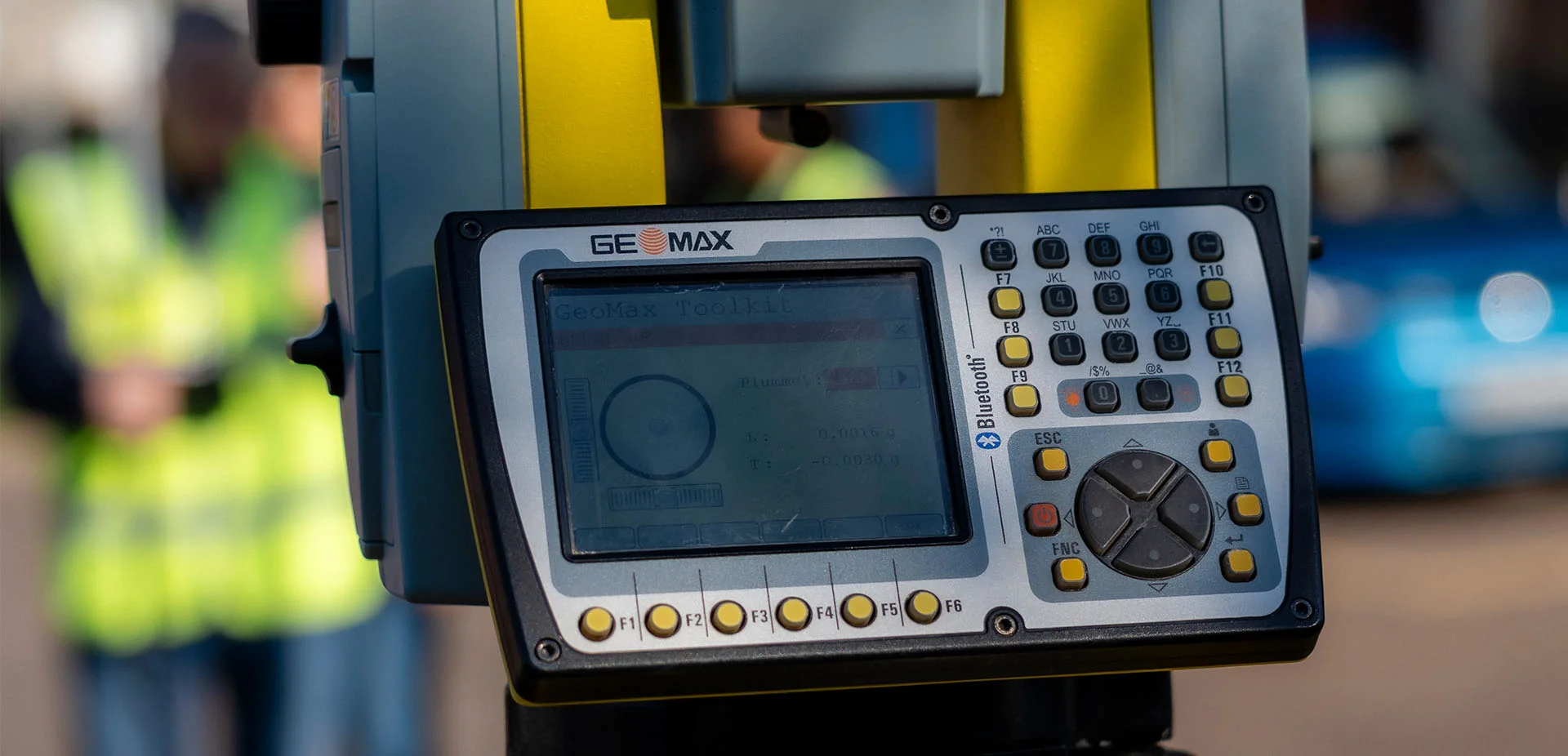 Close‑up of a digital surveying instrument mounted on a tripod, used to measure and record site data during a practical outdoor learning activity.