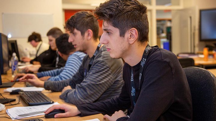 A group of students on a bank of computers
