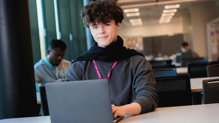 Person working on a laptop computer during an independent study session in a classroom environment.