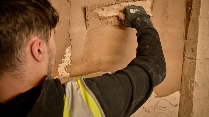Close up of student plastering a wall