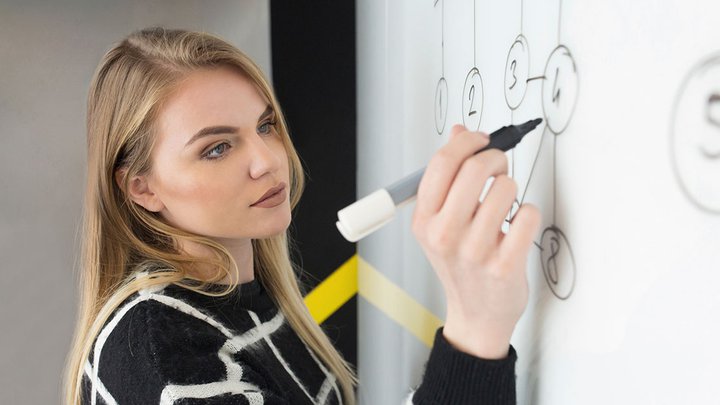 A woman writing on a white board