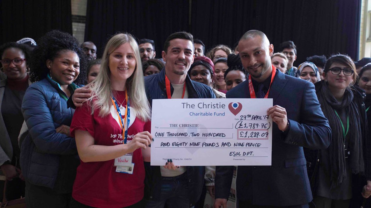 The Manchester College students handing over a fundraiser cheque to The Christie