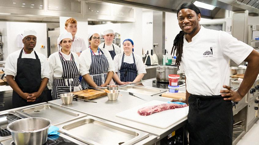 Photograph of professional chef Exose Grant and students at The Manchester College’s Industry Excellence Academy for Hospitality & Catering in the kitchen at 1853 Restaurant.