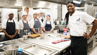Photograph of professional chef Exose Grant and students at The Manchester College’s Industry Excellence Academy for Hospitality & Catering in the kitchen at 1853 Restaurant.