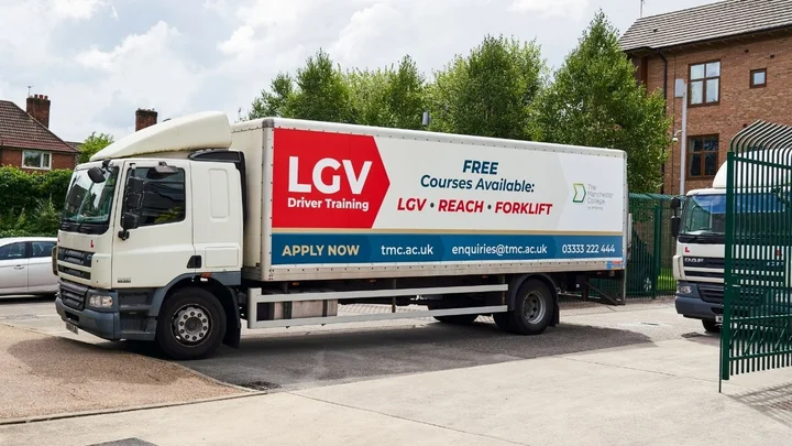 An LGV training truck parked at a driving training centre, displaying signage advertising free LGV, reach truck, and forklift courses.