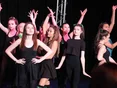 Female students dressed in black dresses dancing