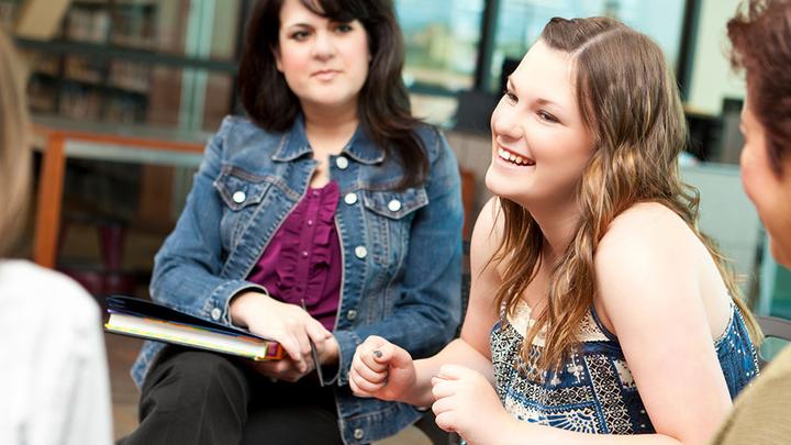 A woman smiling during a group counselling session