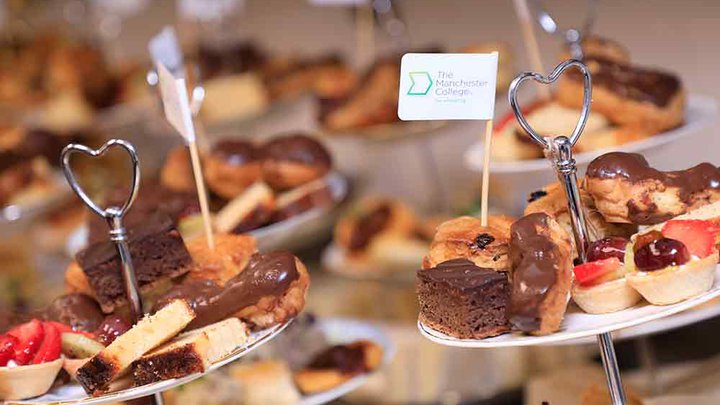 Selection of freshly made cakes with a Manchester College flag sticking out