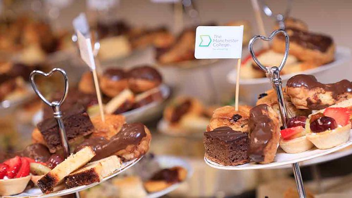 Selection of freshly made cakes with a Manchester College flag sticking out