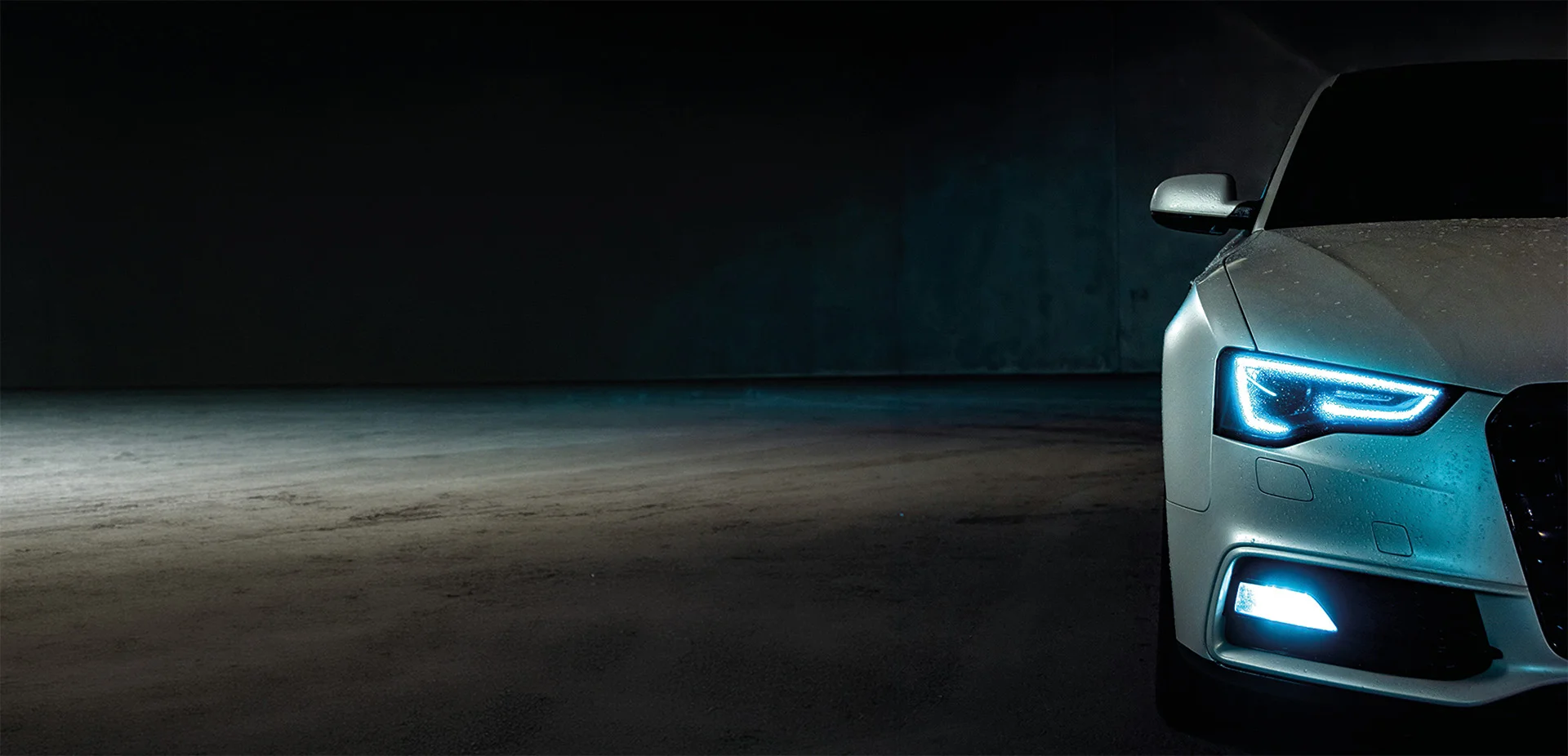 Close-up of a front of a car with it's headlights on