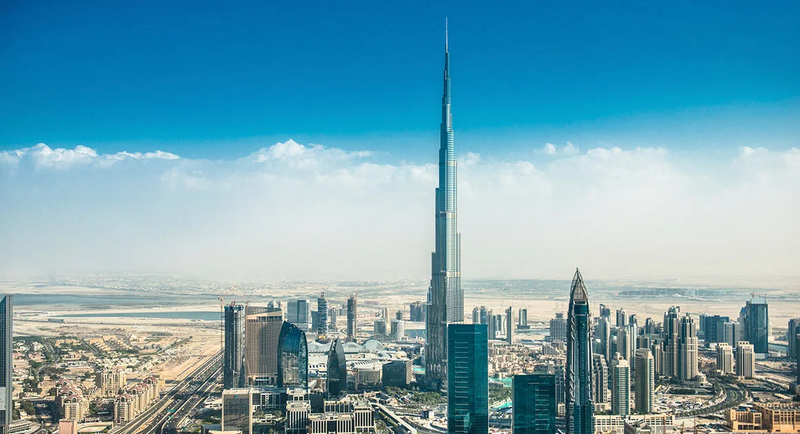 Dubai skyline featuring the Burj Khalifa towering above surrounding skyscrapers on a clear day.
