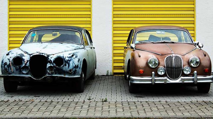 Two cars side-by-side; one with perfect bodywork the other old and in need of repair