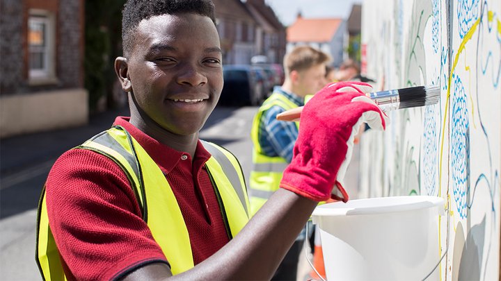 Close-up of a learner helping clean a wall