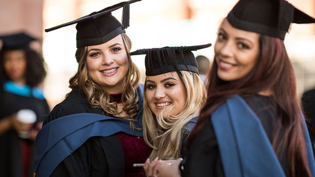 A group of graduates smiling at the camera