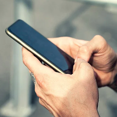 Person using a smartphone, viewed close up with the screen visible in their hands.