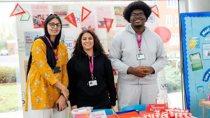 Group of people standing behind an information table during a business and professional services outreach or promotional activity.