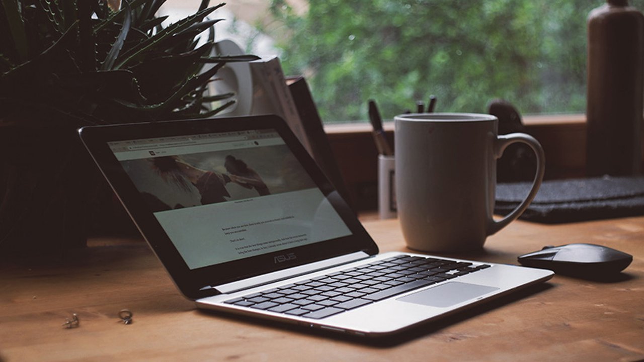 A laptop and a coffee cup on a desk