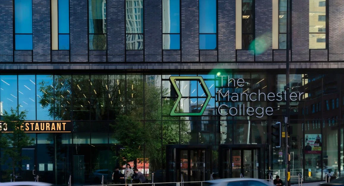 The Manchester College Building Exterior with Logo Signage Above the Doors