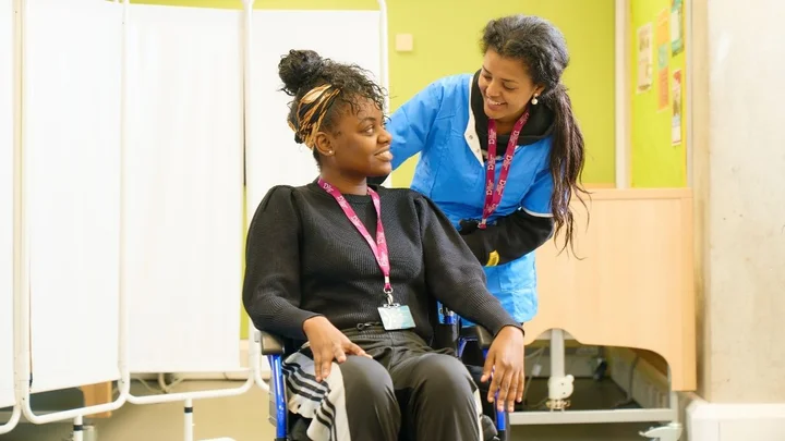 A health and social care learner practising safe wheelchair handling during a practical training session.