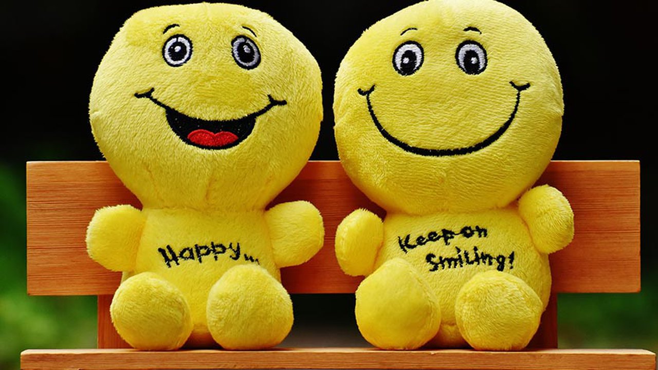 Two smiling toys sat on a bench