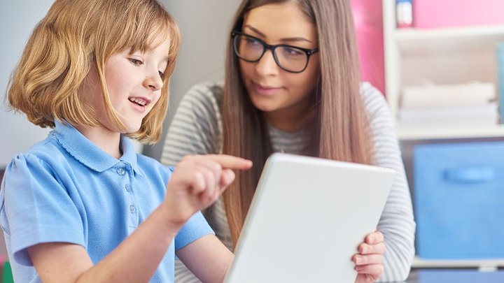 A woman helping a little child read