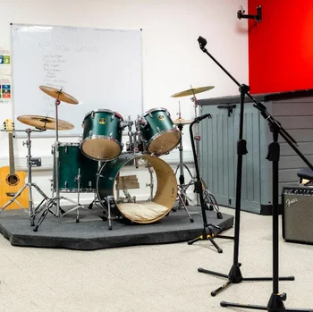 Band rehearsal studio at The Manchester College City Campus Manchester, featuring a drum kit, guitars, amplifiers and microphone stands.