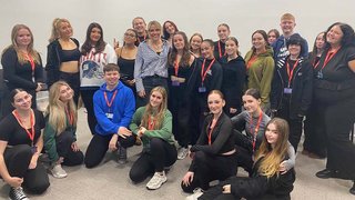 It's a group shot of the Musical Theatre class posing for a picture with Maisie Maguire.