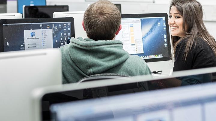 Two students sat at a bank of computers