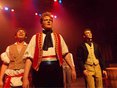 Three male students in costume singing